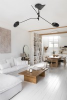 Espace de vie ouvert moderne peint en blanc avec des meubles en bois