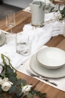 Vaisselle blanche sur table à manger extérieure en bois - détail