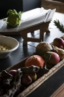 Plateau en bois de fruits et légumes sur le plan de travail de la cuisine de campagne