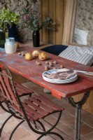 Détail de la table à manger extérieure en bois rouge en détresse sur la terrasse