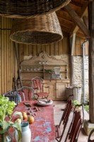 Ancienne commode en bois et table à manger extérieure rouge sur terrasse couverte