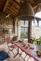 Ancienne commode en bois et table à manger extérieure rouge sur petite terrasse