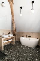 Salle de bain moderne avec sol à motifs et poutres apparentes