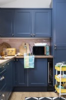 Éléments de cuisine peints en bleu avec des carreaux roses