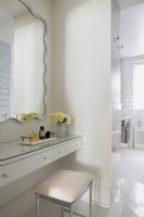 Coiffeuse, miroir et tabouret dans une salle de bain blanche moderne
