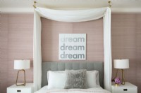 Chambre féminine en rose et blanc avec un auvent à rideaux au-dessus du lit.