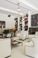 Salon moderne avec fauteuils et œuvres d'art colorées.