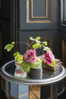 Roses anciennes, feuilles de hêtre et hortensia dans un vase dans une chambre lambrissée