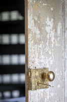 Porte en bois rustique avec poignée de porte en laiton orné dans un ancien cottage en pierre