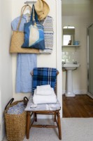 Chaise en bois dans la chambre, tissus rustiques simples et vue sur la salle de bain attenante