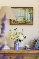Vase de fleurs sur une commode. Peinture vintage de scène d'été et de vieux livres.