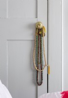 Détail des colliers de perles sur la poignée de porte