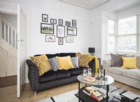 Salon moderne avec canapé noir et coussins jaunes