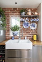 Évier double dans une cuisine moderne avec des murs en briques apparentes