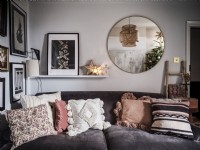 Petit salon avec canapé en velours, étagère et photos