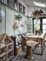 Salle à manger scandinave rustique avec table et décorations de Noël et maison de poupées