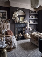Salon bohème avec chaise paon, cheminée ornée avec dressing et étagères