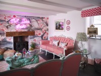 Salon à thème côtier avec mobilier rose et cheminée