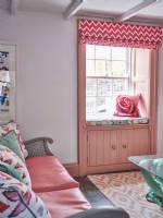 Siège de fenêtre avec coussin rose et store