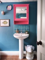 Lavabo de la salle de bain bleue avec miroir rose