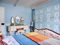 Lit capitonné vintage avec coiffeuse dorée dans une chambre à motifs bleus