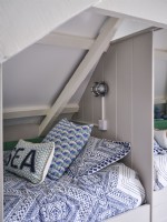 Coussins colorés sur lit intégré dans la chambre loft