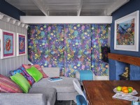Salle à manger colorée avec mur caractéristique, mur lambrissé et œuvres d'art marines