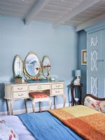 Vanité de coiffeuse vintage dorée dans une chambre à thème côtier bleu