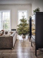 Armoires noires et arbre de Noël devant de grandes fenêtres