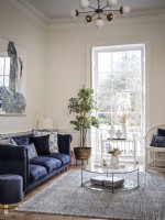 Canapé bleu dans un salon ouvert avec fenêtre caractéristique