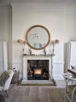 Poêle à bois, cheminée décorative et miroir circulaire