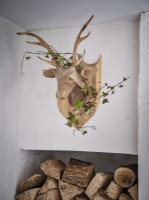 Sculpture en bois de cerf enveloppé dans une guirlande