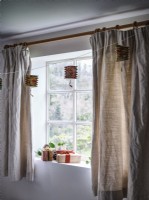 Fenêtre avec décorations suspendues et rideaux beiges