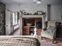 Chambre à coucher campagnarde avec fauteuil et manteau de cheminée