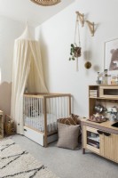 Chambre d'enfant avec baldaquin au-dessus du lit de bébé et cuisine de jeu