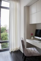 Bureau à domicile moderne avec armoires de rangement et grandes fenêtres avec vue sur la ville.