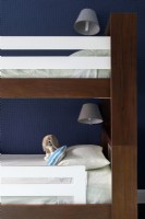 Détails des lits superposés en bois marron et blanc, de l'éclairage et du jouet en peluche.