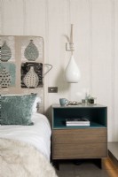 Détail de tête de lit à motifs et table de chevet dans une chambre moderne