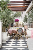 Balcon avec sol en damier et chaises de café français