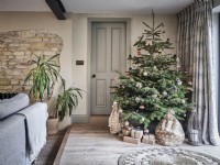 Salon neutre avec briques apparentes et arbre de Noël avec des cadeaux