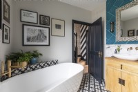 Salle de bain contemporaine avec des carreaux saisissants, une baignoire autoportante et des accents en laiton