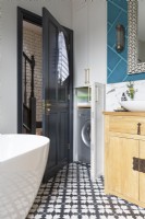 Détail d'un espace de rangement astucieux et d'une machine à laver cachée dans une superbe salle de bains contemporaine