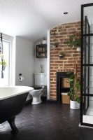 Salle de bain familiale avec baignoire sur pieds et douche de style crittall, briques apparentes et accessoires chromés