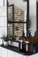 Reflet dans le miroir du manteau de cheminée en briques apparentes et des plantes d'intérieur