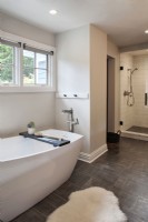 Salle de bain blanche moderne avec baignoire et douche.