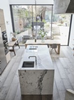 Unité d'île surmontée de marbre dans la cuisine avec portes vitrées