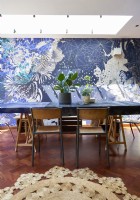 Table à manger contre un mur décoré d'un papier peint design.