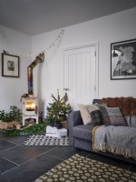 Salon nordique avec canapé, arbre de Noël et poêle à bois