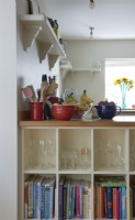 détail des étagères de cuisine avec verres et livres.
