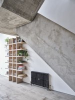 Étagère avec plantes d'intérieur sous escalier en béton
